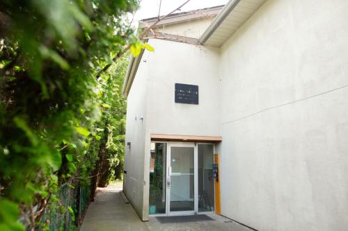 an entrance to a white building with a glass door at The Backyard at Cedar Springs Walk to Lake and Hot Springs in Harrison Hot Springs