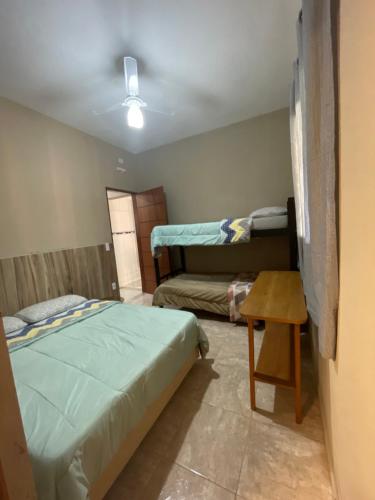 ein Schlafzimmer mit einem Bett und einem Tisch darin in der Unterkunft sitio sonho verde in Serra Negra