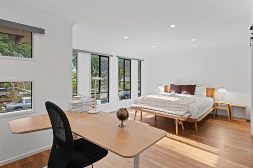 ブリスベンにあるSunnybank Hills Spacious 5BR Home for Familiesのベッドと机とテーブルのある寝室