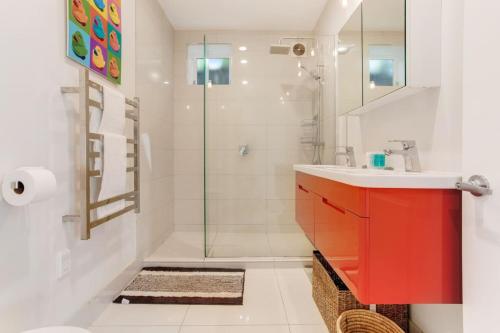 a bathroom with a red cabinet and a shower at Perfect Family Home in Central Auckland in Auckland