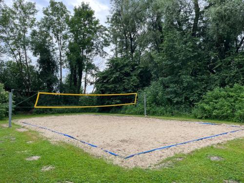 a volley ball net on a sandy field with trees at wallerseehomes 121 in Baierham