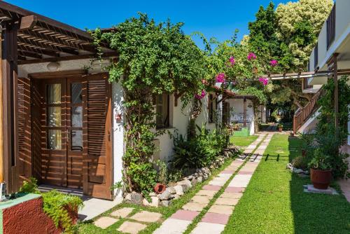 a garden with a house with flowers and plants at Gaia Garden in Kos Town