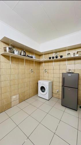 a kitchen with a refrigerator and a washing machine at Studio Laluciole Louis in Libreville