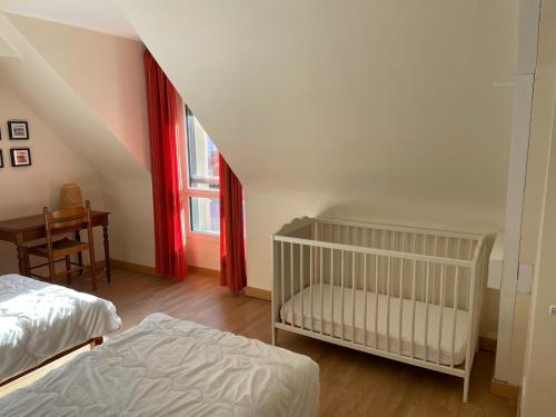 - une chambre avec 2 lits, un lit bébé et une table dans l'établissement Maison avec jardin, proche plage, à Dinard