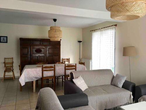 un salon avec un canapé et une salle à manger dans l'établissement Maison avec jardin, proche plage, à Dinard