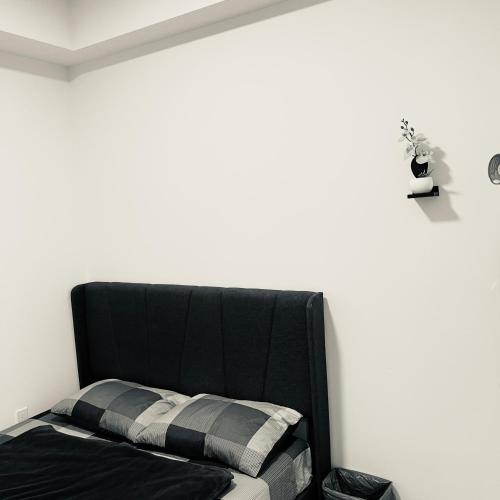 un letto nero in una stanza con parete bianca di Chic Retreat Pet & Smoke-Friendly, Balcony Views, Prime Location a Vaughan