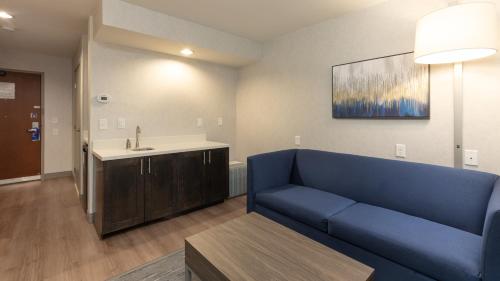 a living room with a blue couch and a sink at Holiday Inn Express Bellingham by IHG in Bellingham