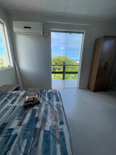 une chambre avec un lit et une porte donnant sur un balcon dans l'établissement Casa con vista al mar, à Búzios