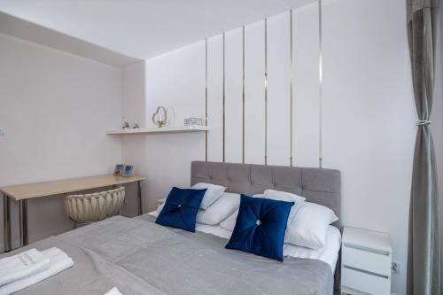 a bedroom with a large bed with blue pillows at Rezydencja Wrocław Legnicka in Wrocław