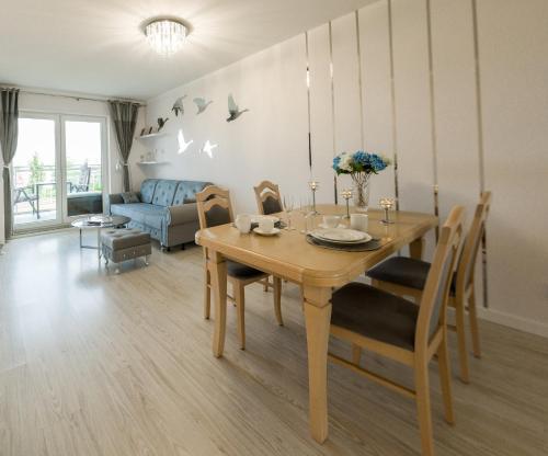 a dining room with a table and a couch at Rezydencja Wrocław Legnicka in Wrocław