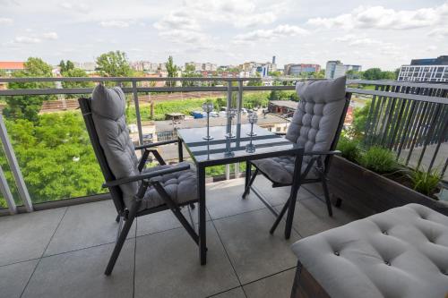 a balcony with a glass table and two chairs at Rezydencja Wrocław Legnicka in Wrocław