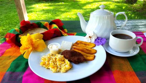 a plate of breakfast food and a cup of coffee at Hotel Villas del Valle in Valle de Ángeles