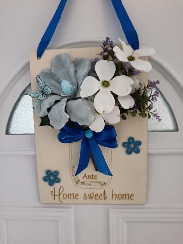 a picture of a home sweet home sign with flowers at Apartmani Jozić in Garešnica