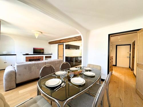 une salle à manger avec une table, des chaises et un canapé dans l'établissement L'Iconic - By BEST KEYS - Vue Exceptionnelle Cathédrale - Terrasse Privée- Prestige en Plein Cœur de Ville - Tout à Pied - Standing Charme & Calme - Check-in Autonome - Internet WiFi Fibre offert - Smart TV - Machine à Café Nespresso, à Sens