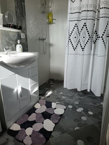 a bathroom with a sink and a toilet and a shower at Apartmani Jozić in Garešnica