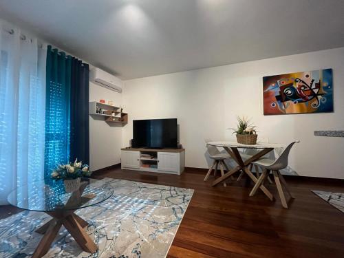 a living room with a table and a tv at Casa do Ribeiro in Geres