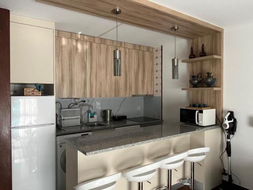 a kitchen with a white refrigerator and a counter with stools at Casa do Ribeiro in Geres