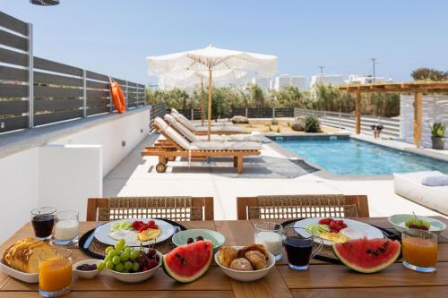 a table with plates of food and fruit on a balcony at calmare collection hotel in Plaka