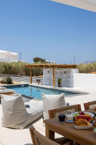 a table with food on it next to a swimming pool at calmare collection hotel in Plaka