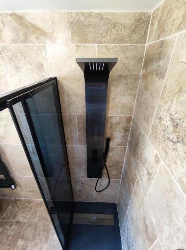 une douche avec une porte vitrée dans une salle de bain dans l'établissement Chez ilhem, à Saint-Maurice-dʼArdèche