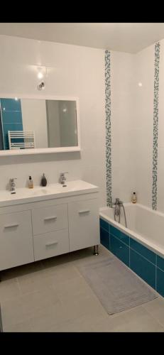 a bathroom with two sinks and a tub and a mirror at Maison vacances - cure thermale in Eugénie-les-Bains