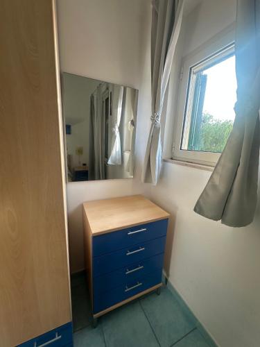a bathroom with a blue dresser and a mirror at La Nassa Rooms in San Domino