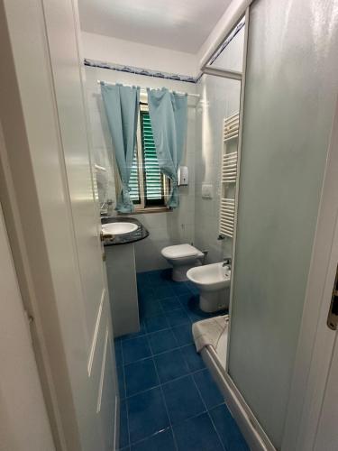 a bathroom with a toilet and a sink and a mirror at La Nassa Rooms in San Domino