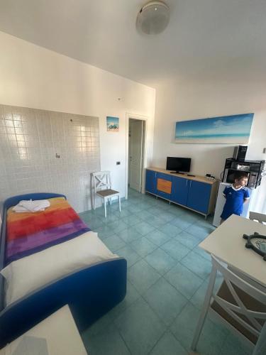 a bedroom with a bed and a table and a kitchen at La Nassa Rooms in San Domino
