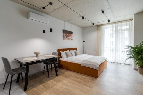 a bedroom with a bed and a table and a desk at Prime Rest Apartments in Lviv