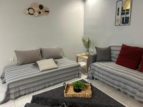 a living room with a couch and a table at Mano's house 15 minutes from the airport in Artemida