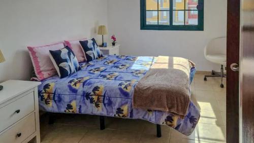 サンミゲル・デ・アボナにあるApartment with Pool in San Miguel de Abona 60 m²のベッドルーム(紫色の掛け布団付きのベッド1台付)