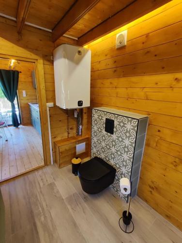 a room with a toilet in a wooden cabin at Le chalet de Joyce spa et piscine in Saint-Aubin-des-Préaux