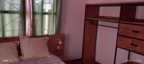 a bedroom with a bed and a dresser and a mirror at Antsaly Lodge in Anjomakely