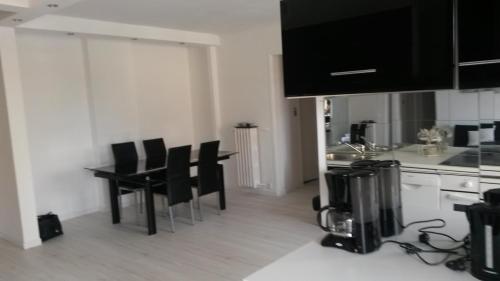 une cuisine avec des chaises noires et un comptoir dans l'établissement appartement alexandre III Cannes, à Cannes