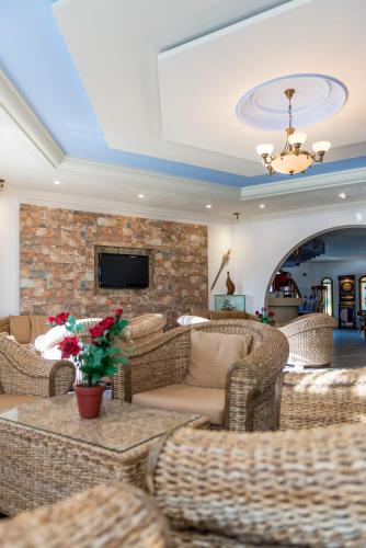 a living room with wicker furniture and a tv at Gaia Garden in Kos Town
