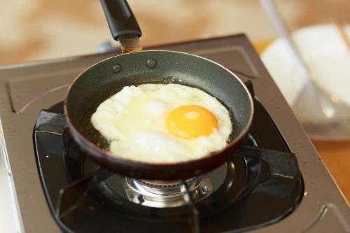 a fried egg in a pan on a stove at Hopapa Hotel & Spa Phu Quoc in Phu Quoc