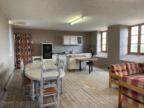 une cuisine et un salon avec une table et un canapé dans l'établissement gite LFMFARM maison tout confort, à La Celle-sous-Gouzon