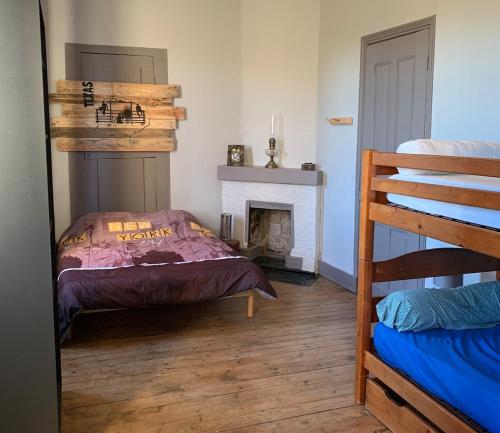 une chambre avec un lit et une cheminée et un lit superposé dans l'établissement gite LFMFARM maison tout confort, à La Celle-sous-Gouzon