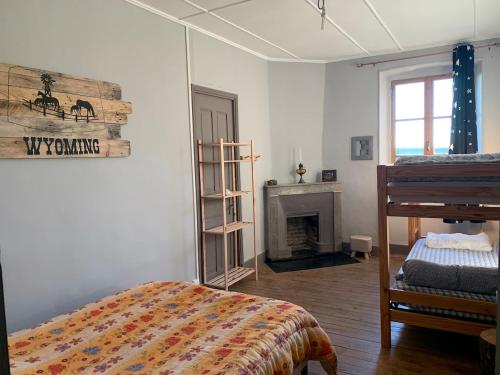 Cette chambre blanche dispose d'un lit et d'une cheminée. dans l'établissement gite LFMFARM maison tout confort, à La Celle-sous-Gouzon