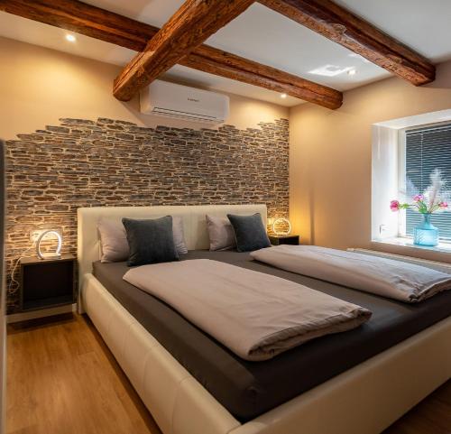 a large bed in a room with a brick wall at Ferienhaus Nißmitz No.32 in Freyburg