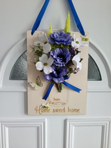 a sign hanging on a door with a bouquet of flowers at Apartmani Jozić in Garešnica