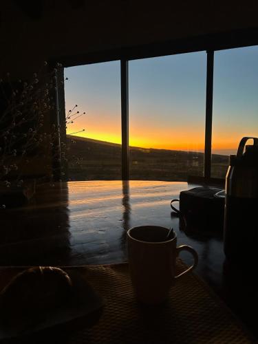 a coffee cup sitting on a table in front of a window at Vivacs del Plata in Tupungato