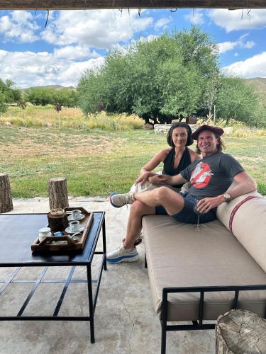 a man and woman sitting on a couch at Vivacs del Plata in Tupungato