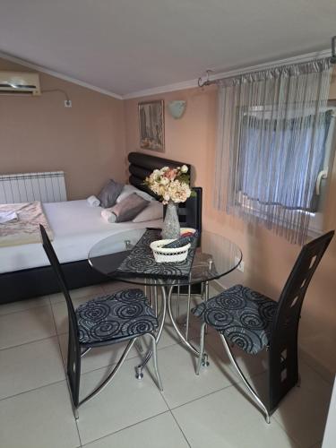 a room with a table and chairs and a bed at Apartments Kordic in Radanovići