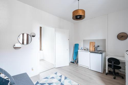 une pièce blanche avec une cuisine et un bureau dans l'établissement Studio cosy proche Centre ville & Gare, à Amiens