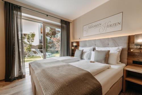 a bedroom with two beds and a large window at Apartment Sella in Siusi