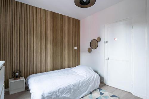 - une chambre avec un lit et un mur rayé dans l'établissement Studio cosy proche Centre ville & Gare, à Amiens