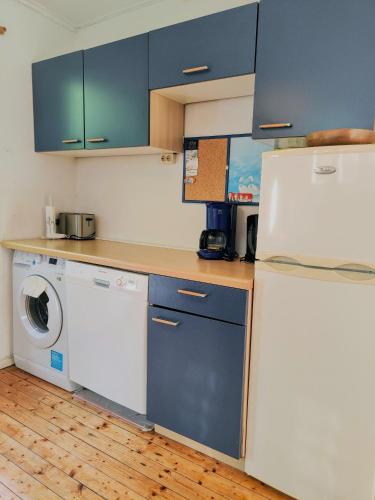 a kitchen with a refrigerator and a washing machine at Haus Ole 