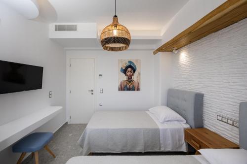 a bedroom with a bed and a pendant light at calmare collection hotel in Plaka