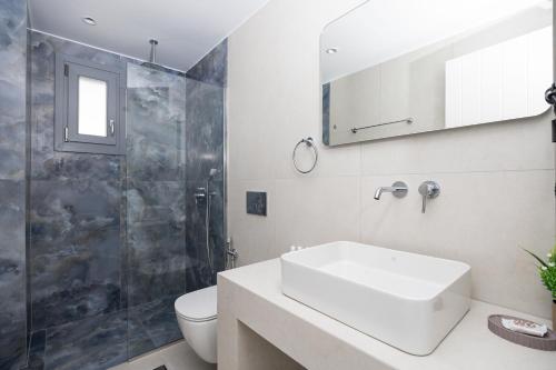 a bathroom with a sink and a shower and a toilet at calmare collection hotel in Plaka